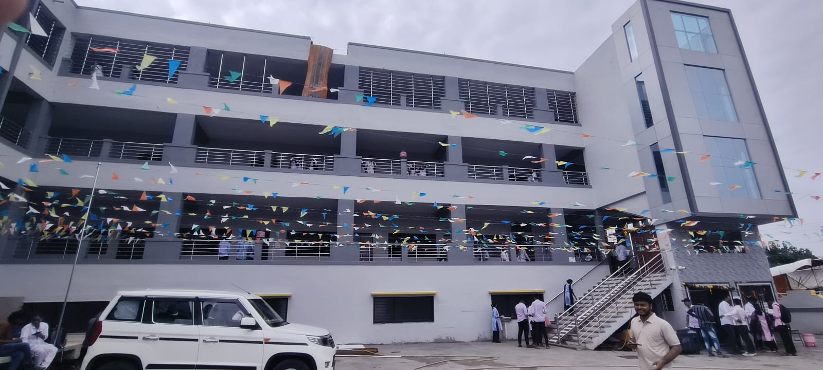 Students gathered at the newly inaugurated building, decorated with flags